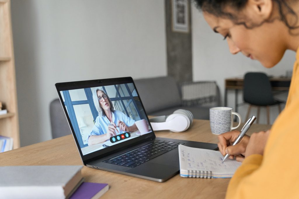 African American female student having video educational class on laptop.